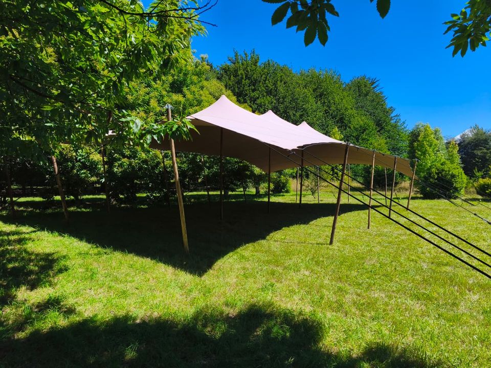Carpa tensada para boda instalada en un jardín verde