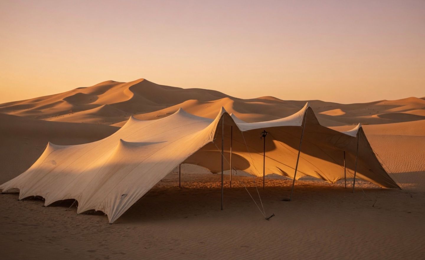 Carpa beduina tensada para eventos instalada entre dunas al atardecer