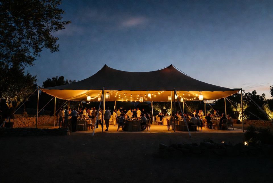 Evento nocturno bajo una carpa beduina tensada e iluminada